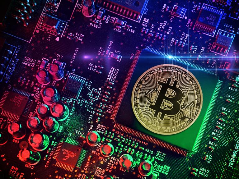 Computerchip mit Bitcoin-Münze, Symbolfoto Computerchip mit Bitcoin-Münze, Symbolfoto