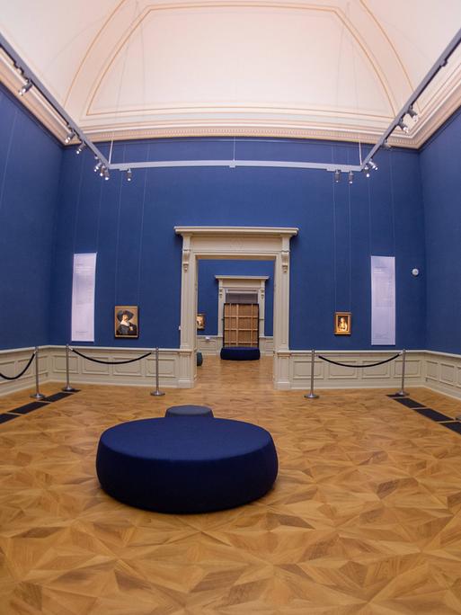 Eine Mitarbeiterin betrachtet die Bilder eine Ausstellung im Herzöglichen Museum Gotha. 