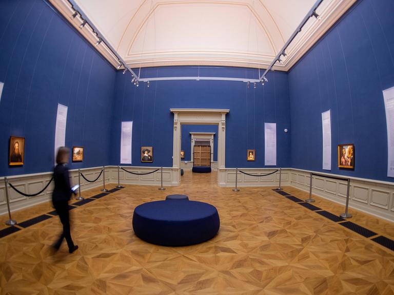 Eine Mitarbeiterin betrachtet die Bilder eine Ausstellung im Herzöglichen Museum Gotha. 