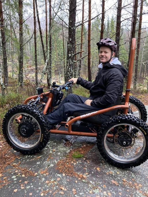 Der Physiotherapeut Sigurd Groven sitzt in seinem selbstgebauten Rollstuhl, der wie ein Kettcar aussieht.