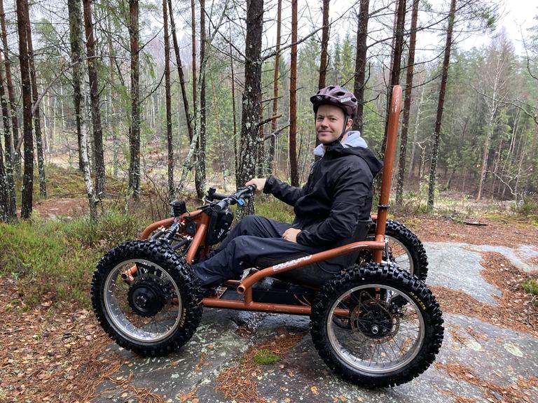 Der Physiotherapeut Sigurd Groven sitzt in seinem selbstgebauten Rollstuhl, der wie ein Kettcar aussieht.