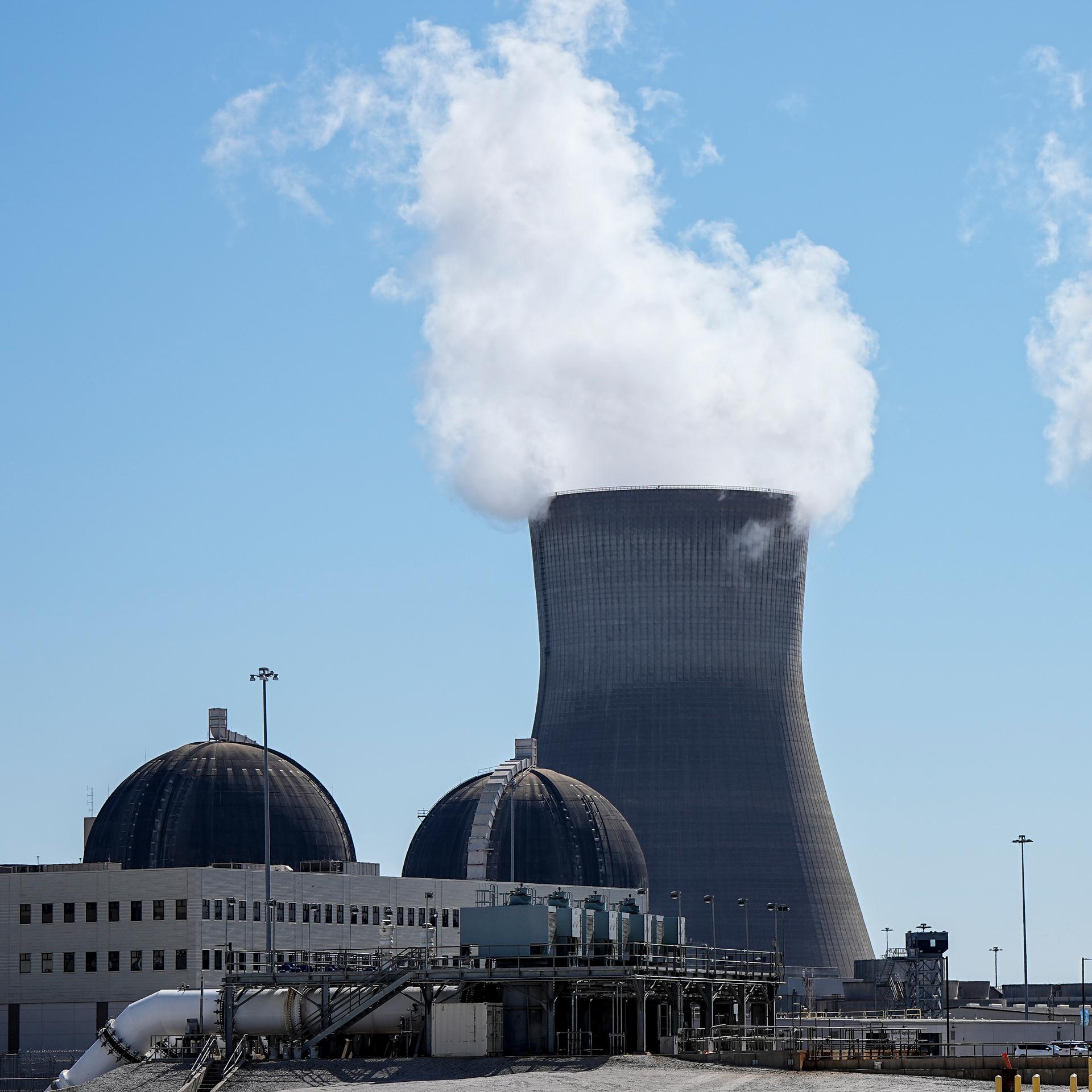 Hinter zwei kuppelförmigen Reaktorhallen stehen Kühltürme, aus denen Wasserdampf quillt