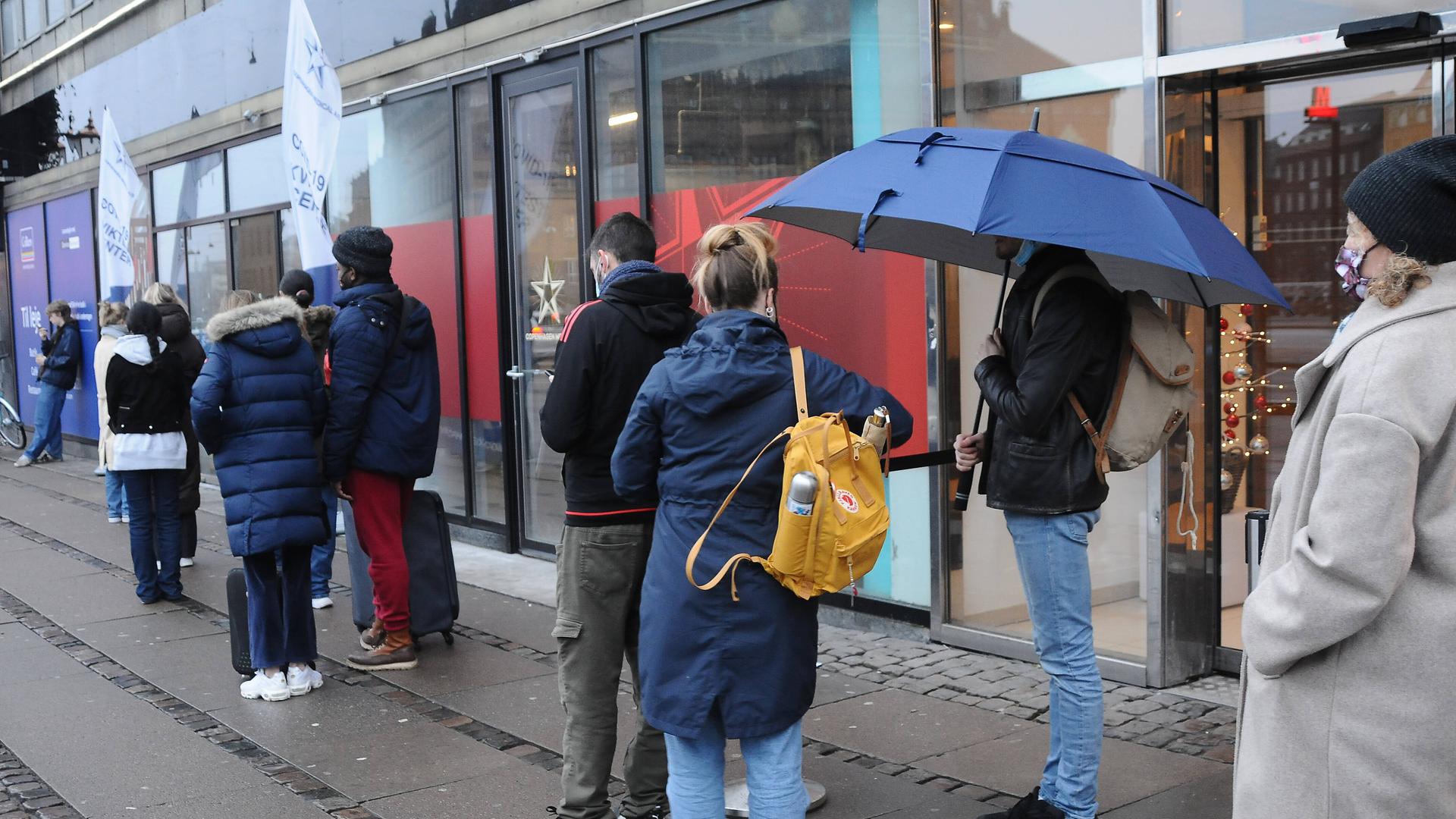 In Kopenhagen stehen Menschen am 30. Dezember in einer Einkaufspassage in einer Schlange, um in einem Testzentrum einen Corona-Schnelltest machen zu lassen.