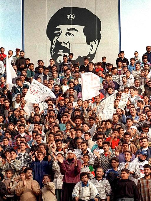 Über einer Menschenmenge im Irak prangt ein riesiges Konterfei von Diktator Saddam Hussein. Die Aufnahme wurde Ende der 90er Jahre gemacht. 