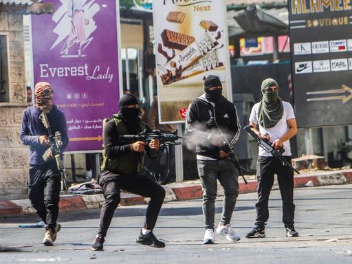 Maskierte bewaffnete Palästinenser schießen während einer Razzia der israelischen Armee im Flüchtlingslager Jenin im Norden des besetzten Westjordanlandes auf israelische Armeekräfte, 03.07.2023.