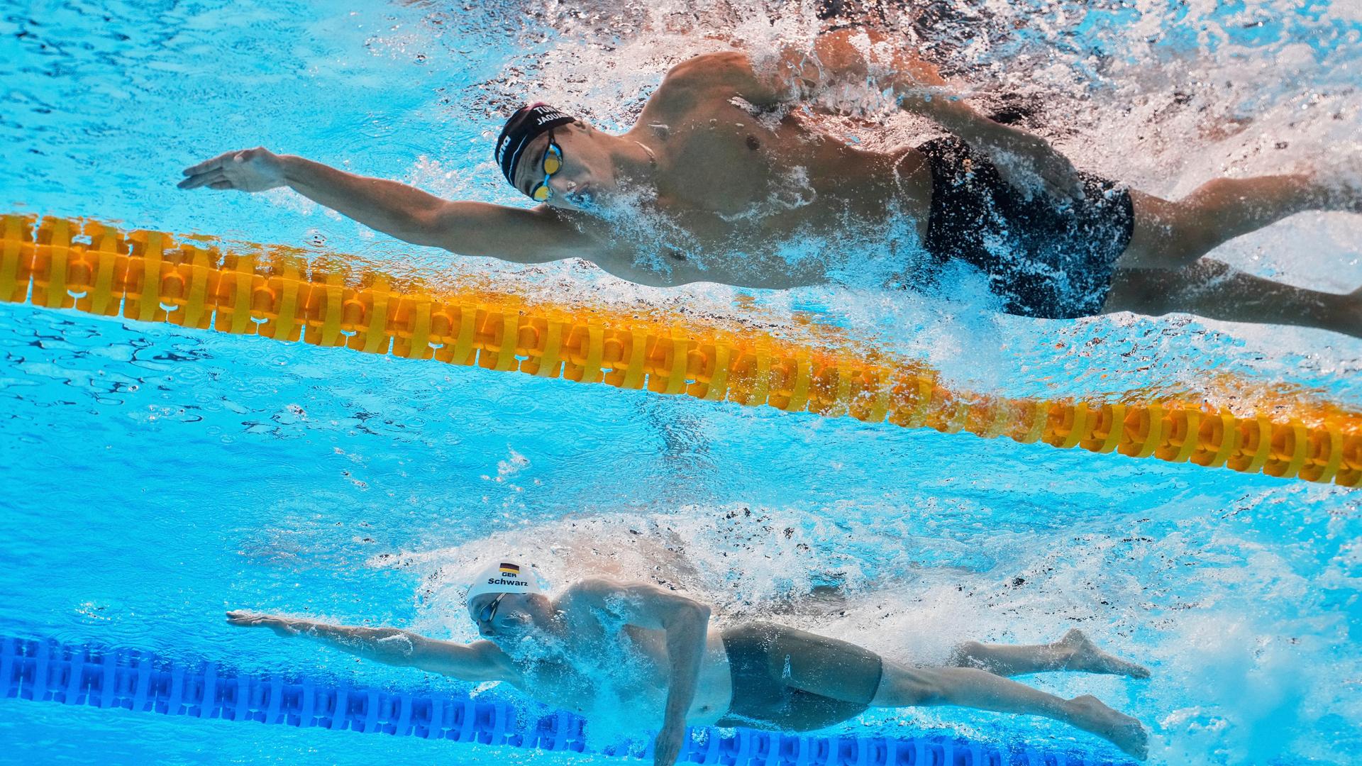 Das Bild zeigt den Schwimmer Sven Schwarz im Wasser. Das Foto wurde von einer Kamera im Becken von unten aufgenommen. Im Hintergrund ist ein weiterer Schwimmer zu sehen, der hinter Schwarz das Nachsehen hat. Das Bild zeigt den Schwimmer Sven Schwarz im Wasser. Das Foto wurde von einer Kamera im Becken von unten aufgenommen. Im Hintergrund ist ein weiterer Schwimmer zu sehen, der hinter Schwarz das Nachsehen hat.