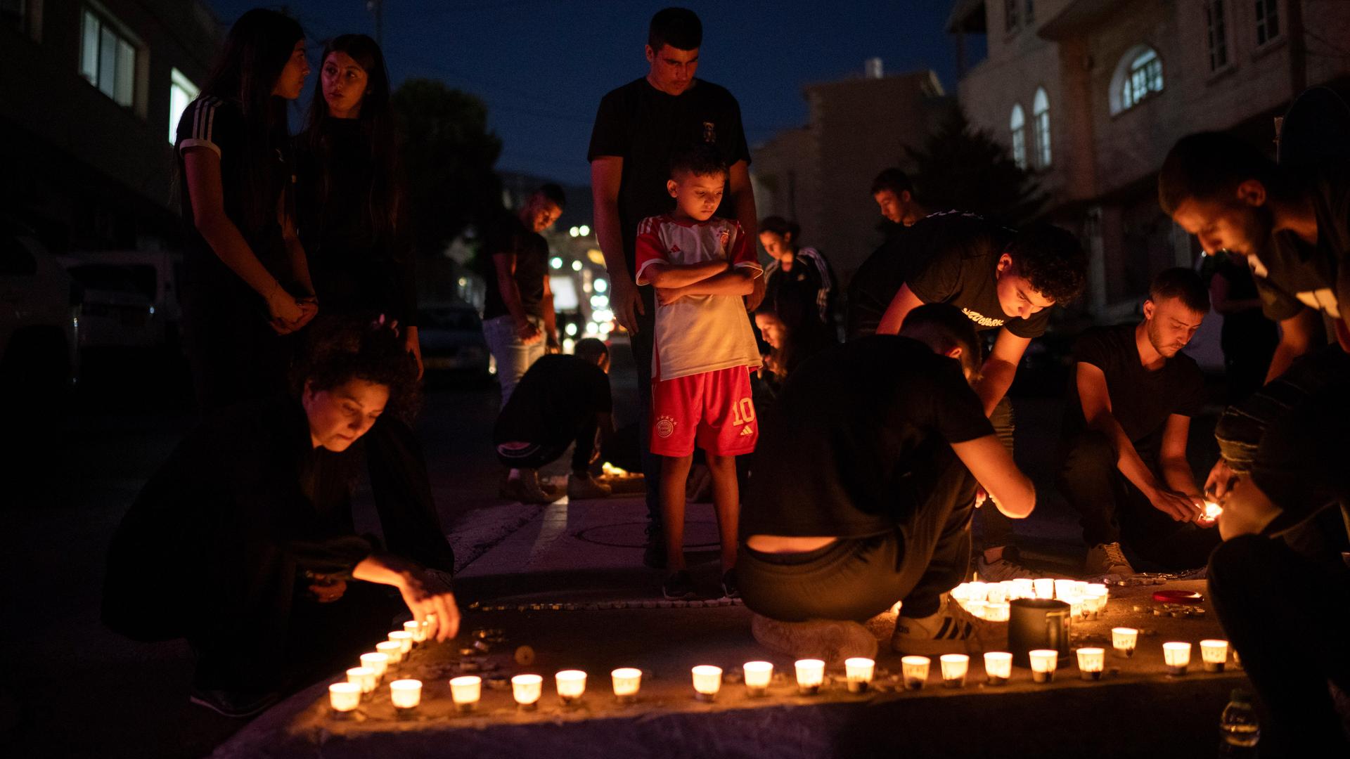Das Foto zeigt Menschen, die Trauerkerzen für die Opfer des Raketeneinschlags auf dem Golan entzünden.