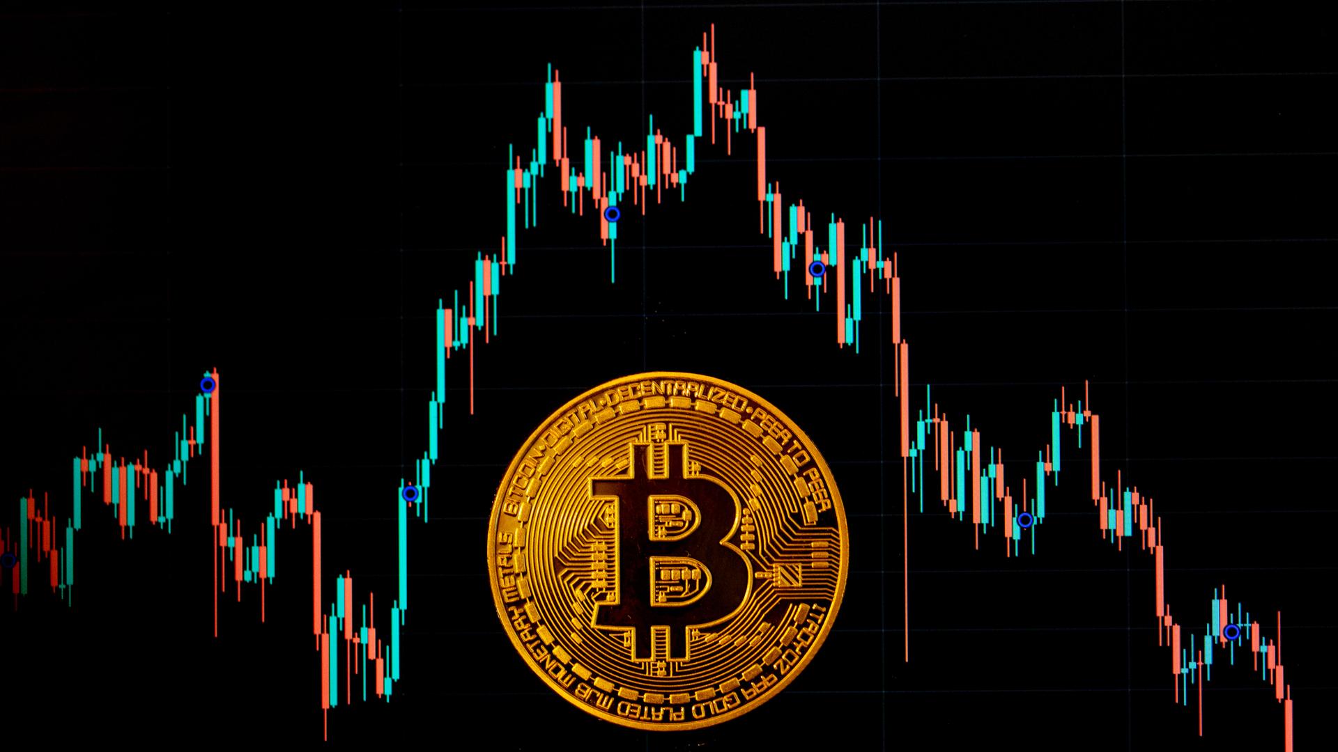 Eine Bitcoin-Münze liegt auf einem Bildschirm, der den Bitcoin - US-Dollar Kurs zeigt. Eine Bitcoin-Münze liegt auf einem Bildschirm, der den Bitcoin - US-Dollar Kurs zeigt.