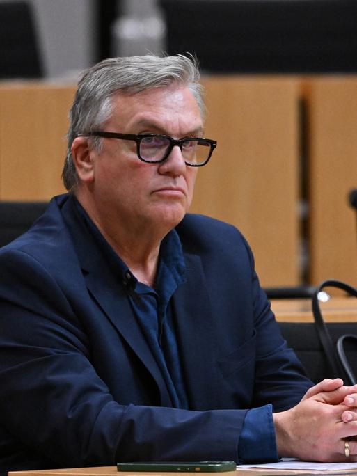 Hape Kerkeling sitzt während einer mündlichen Anhörung zu einem Parteiverbotsverfahren gegen die AfD auf Bundesebene im Plenarsaal des Thüringer Landtags. Er schaut ernst, seine Hände liegen auf dem Tisch, an dem er sitzt. Hape Kerkeling sitzt während einer mündlichen Anhörung zu einem Parteiverbotsverfahren gegen die AfD auf Bundesebene im Plenarsaal des Thüringer Landtags. Er schaut ernst, seine Hände liegen auf dem Tisch, an dem er sitzt.