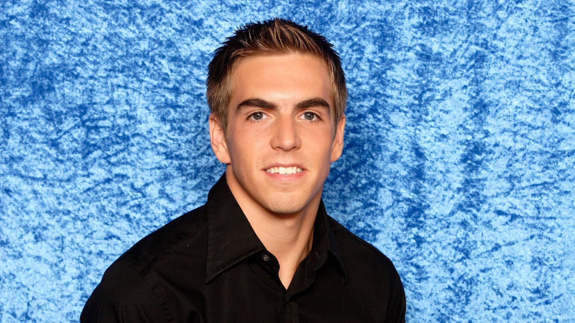 Poträt des Fußballers Philipp Lahm im schwarzen Hemd vor blauem Hintergrund. Poträt des Fußballers Philipp Lahm im schwarzen Hemd vor blauem Hintergrund.