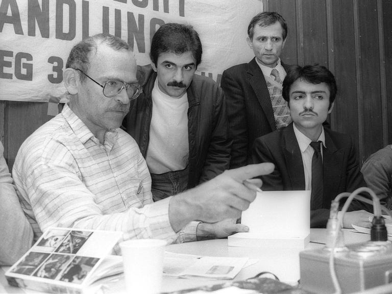 1985: Günter Wallraff stellt sein Buch "Ganz unten" in Anwesenheit seiner ehemaligen Arbeitskollegen  in Duisburg vor. Er zeigt mit dem Finger ins Publikum.