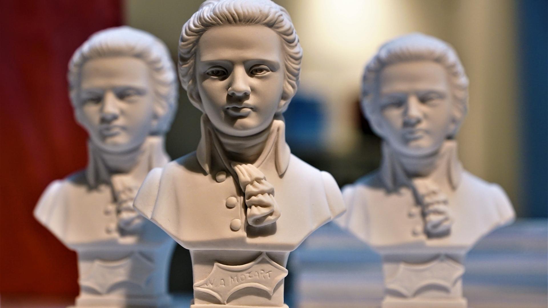 Drei weiße Mozart-Souvenier-Büsten stehen dicht beieinander.