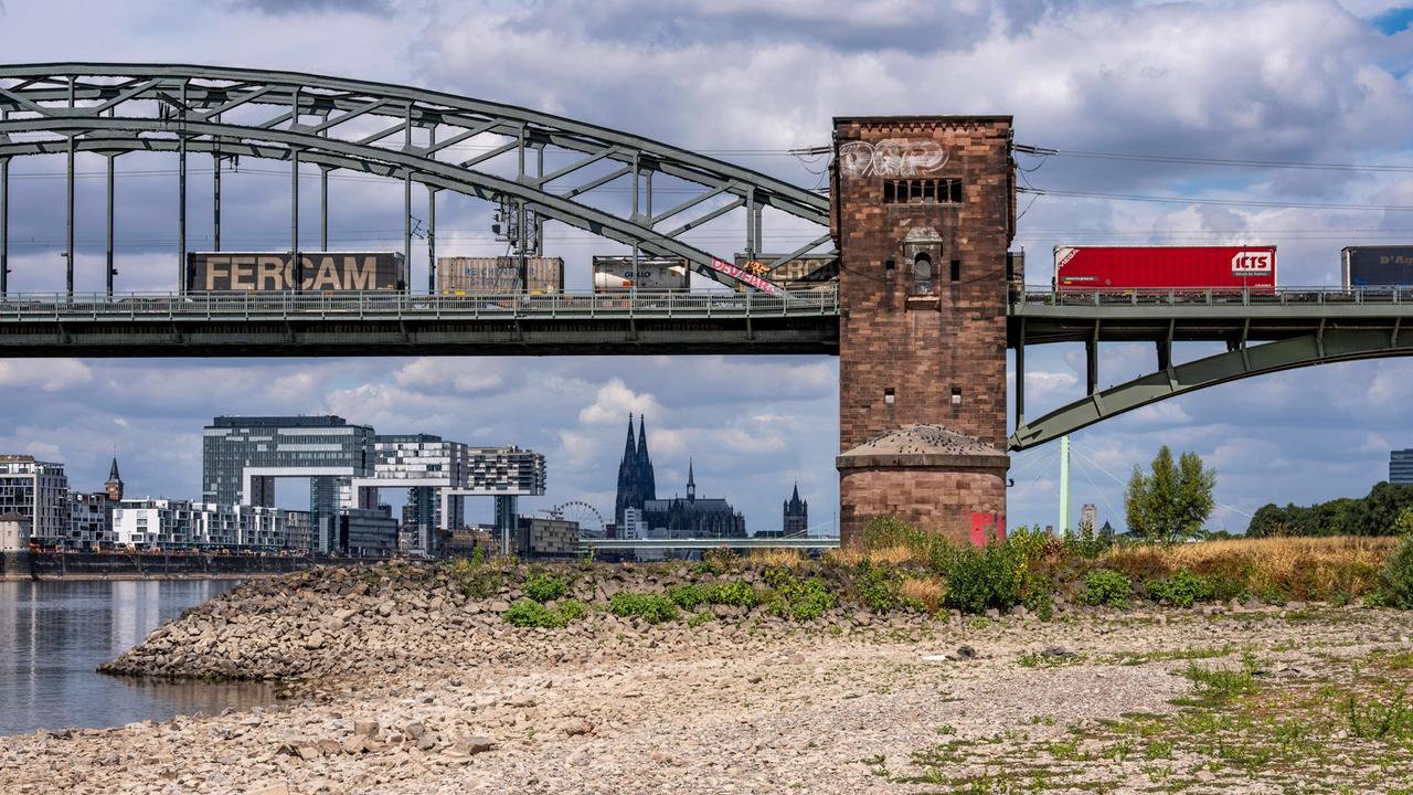 Niedrigwasser im Rhein bei Köln, Blick vom rechtsrheinischen Ufer über die Poller Wiesen, Richtung Norden auf die Südbrücke, die von LKWs überquert wird