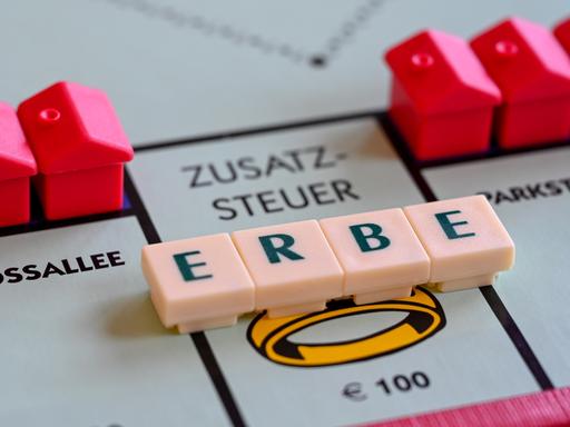Ein Monopoly-Spielbrett mit dem aus Scrabble-Buchstaben gelegten Wort Erbe, das auf dem Feld "Zusatzsteuer" liegt Ein Monopoly-Spielbrett mit dem aus Scrabble-Buchstaben gelegten Wort Erbe, das auf dem Feld "Zusatzsteuer" liegt