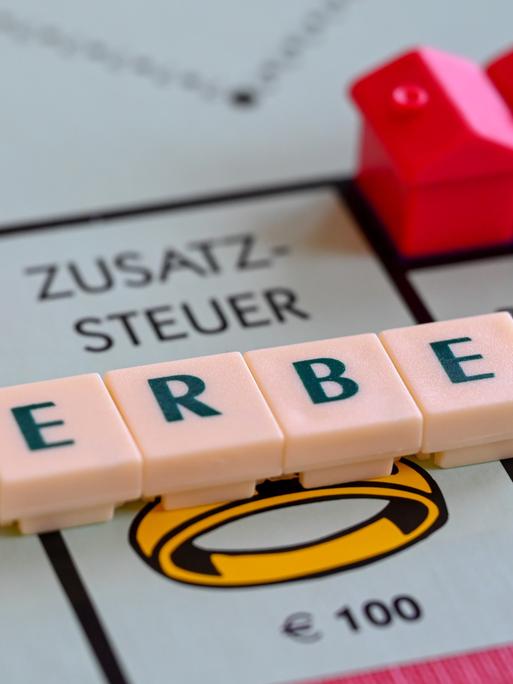 Ein Monopoly-Spielbrett mit dem aus Scrabble-Buchstaben gelegten Wort Erbe, das auf dem Feld "Zusatzsteuer" liegt Ein Monopoly-Spielbrett mit dem aus Scrabble-Buchstaben gelegten Wort Erbe, das auf dem Feld "Zusatzsteuer" liegt