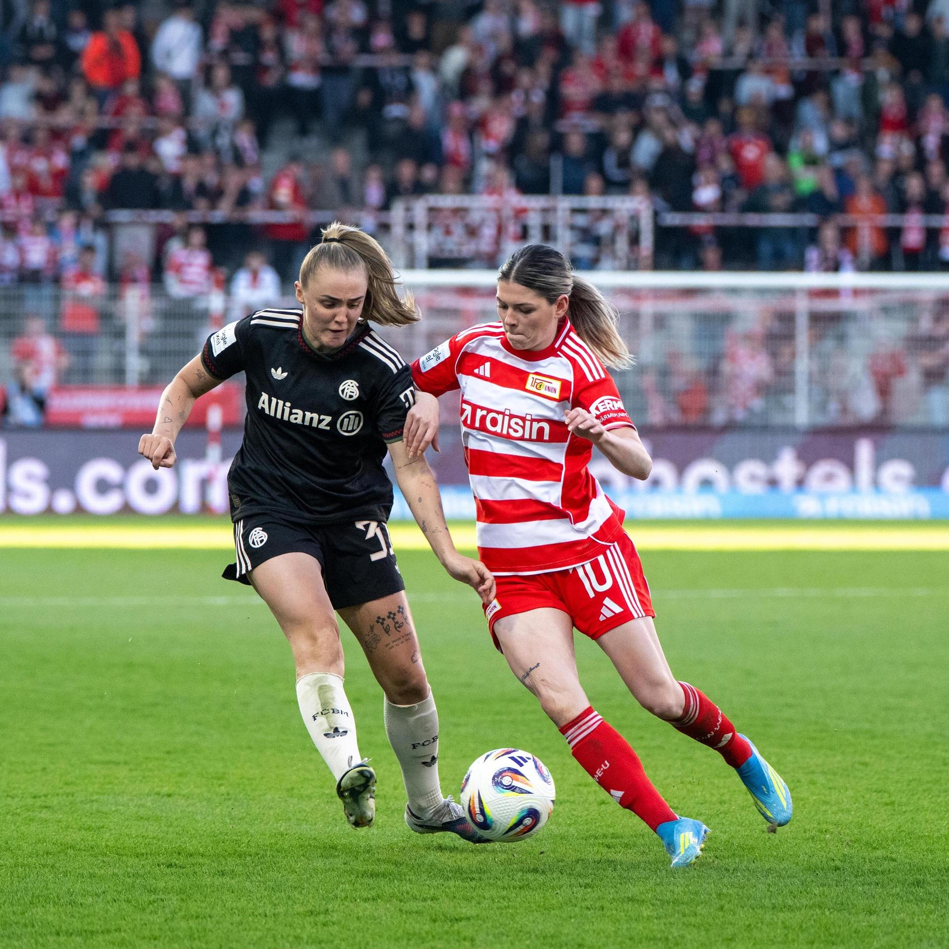 Stanway und Campbell kämpfen um den Ball. Ihre Oberarme berühren sich. Die Blicke sind auf den Ball gerichtet.