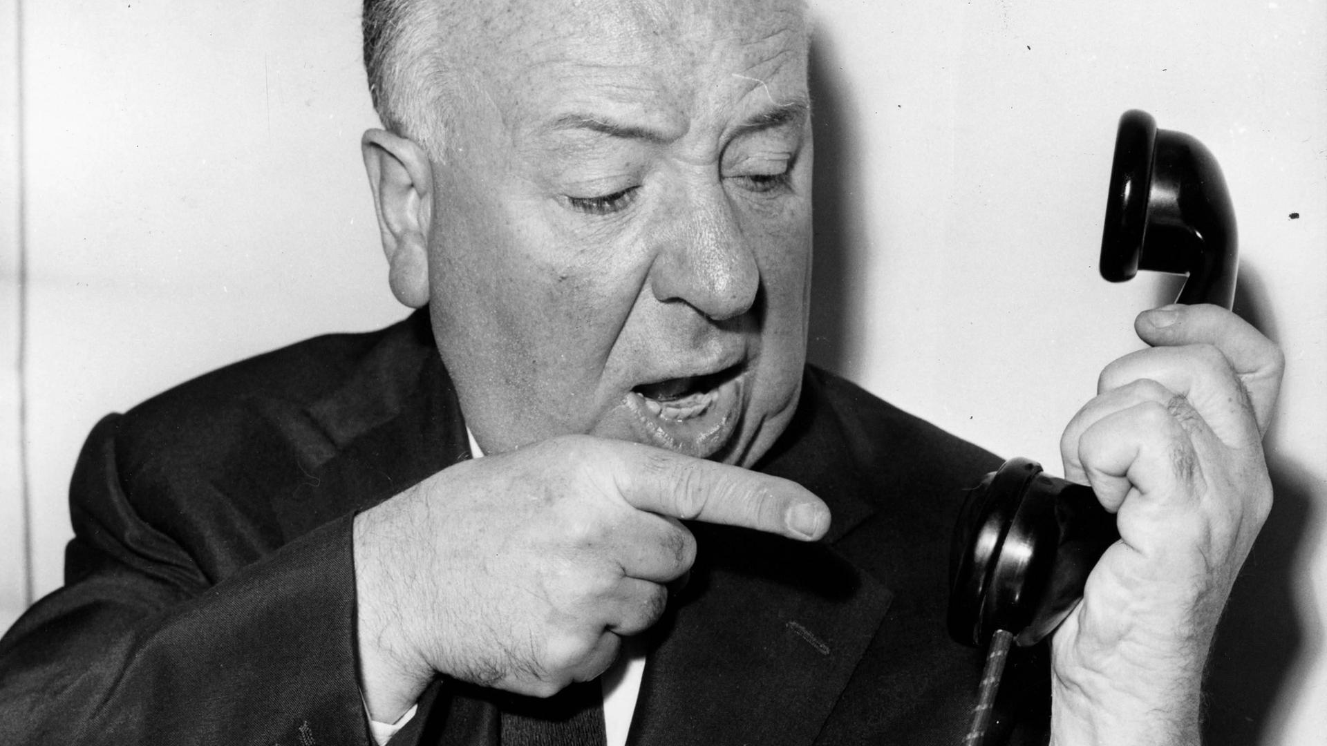 Der Filmemacher Alfred Hitchcock meckert in einer gestellten Szene in einen Telefonhörer