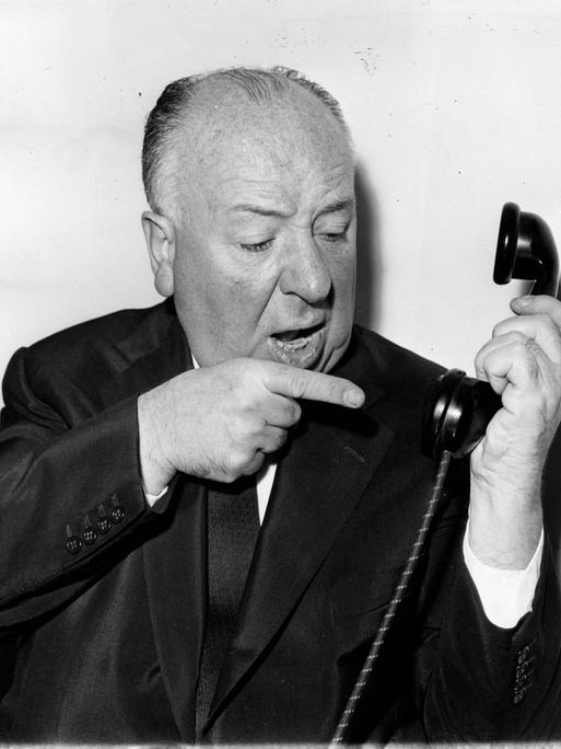 Der Filmemacher Alfred Hitchcock meckert in einer gestellten Szene in einen Telefonhörer