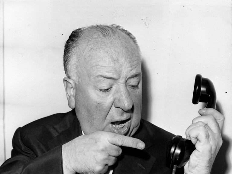 Der Filmemacher Alfred Hitchcock meckert in einer gestellten Szene in einen Telefonhörer