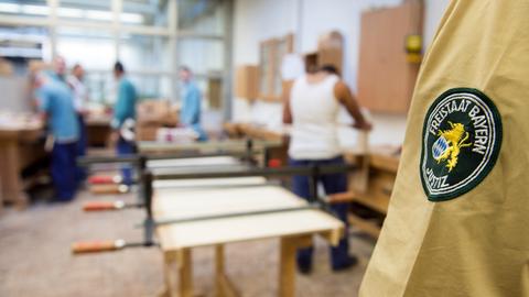 Ein Justizbeamte beaufsichtigt die Arbeit von Häftlingen.