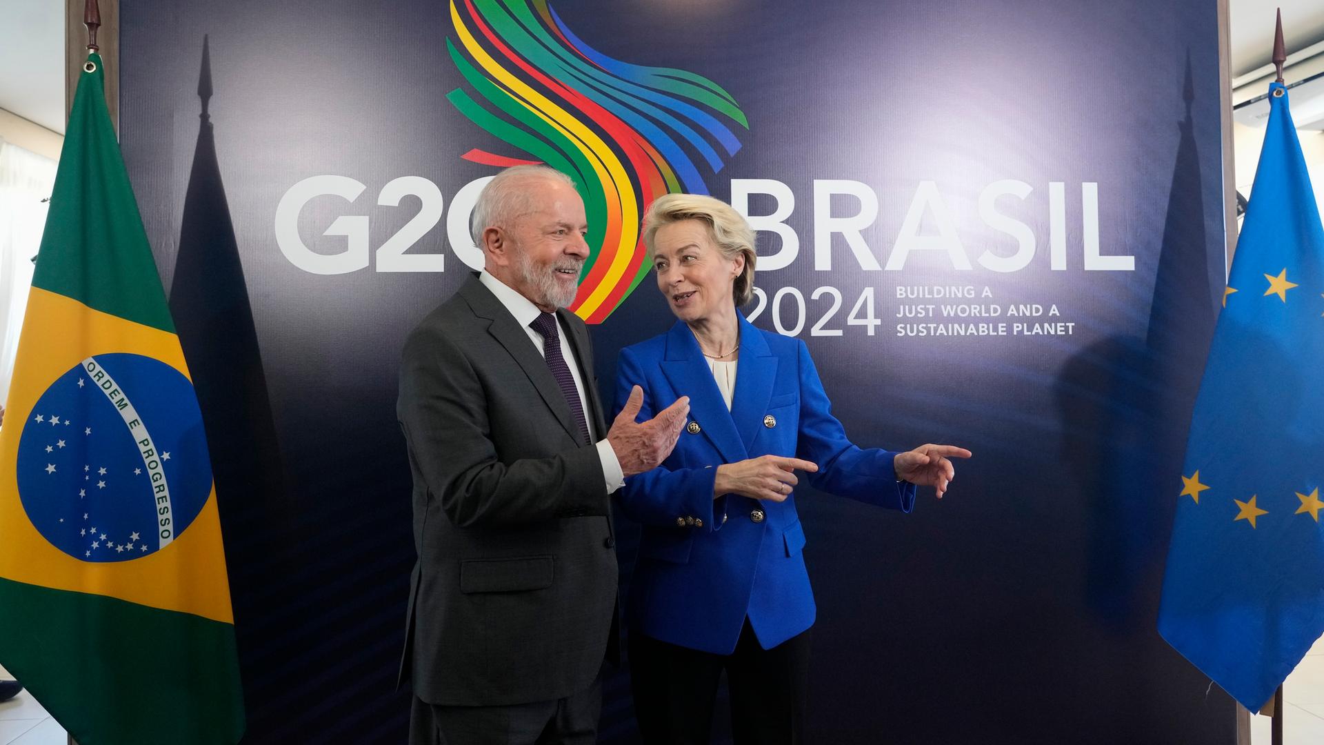 Der Gastgeber und brasilianische Präsident Luiz Inacio Lula da Silva gemeinsam mit EU-Kommissionspräsidentin Ursula von der Leyen vor einer Fototapete mit dem Logo des G20-Gipfels in Rio de Janeiro. 