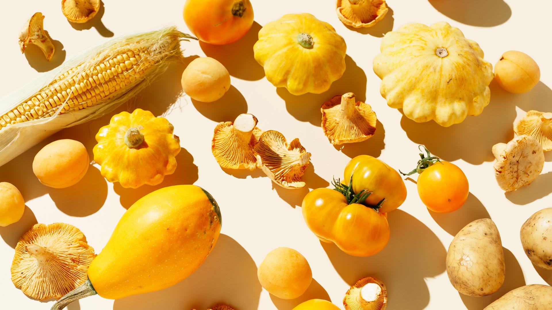 Frisches gelbes Bio-Gemüse und Obst auf hellem Hintergrund.