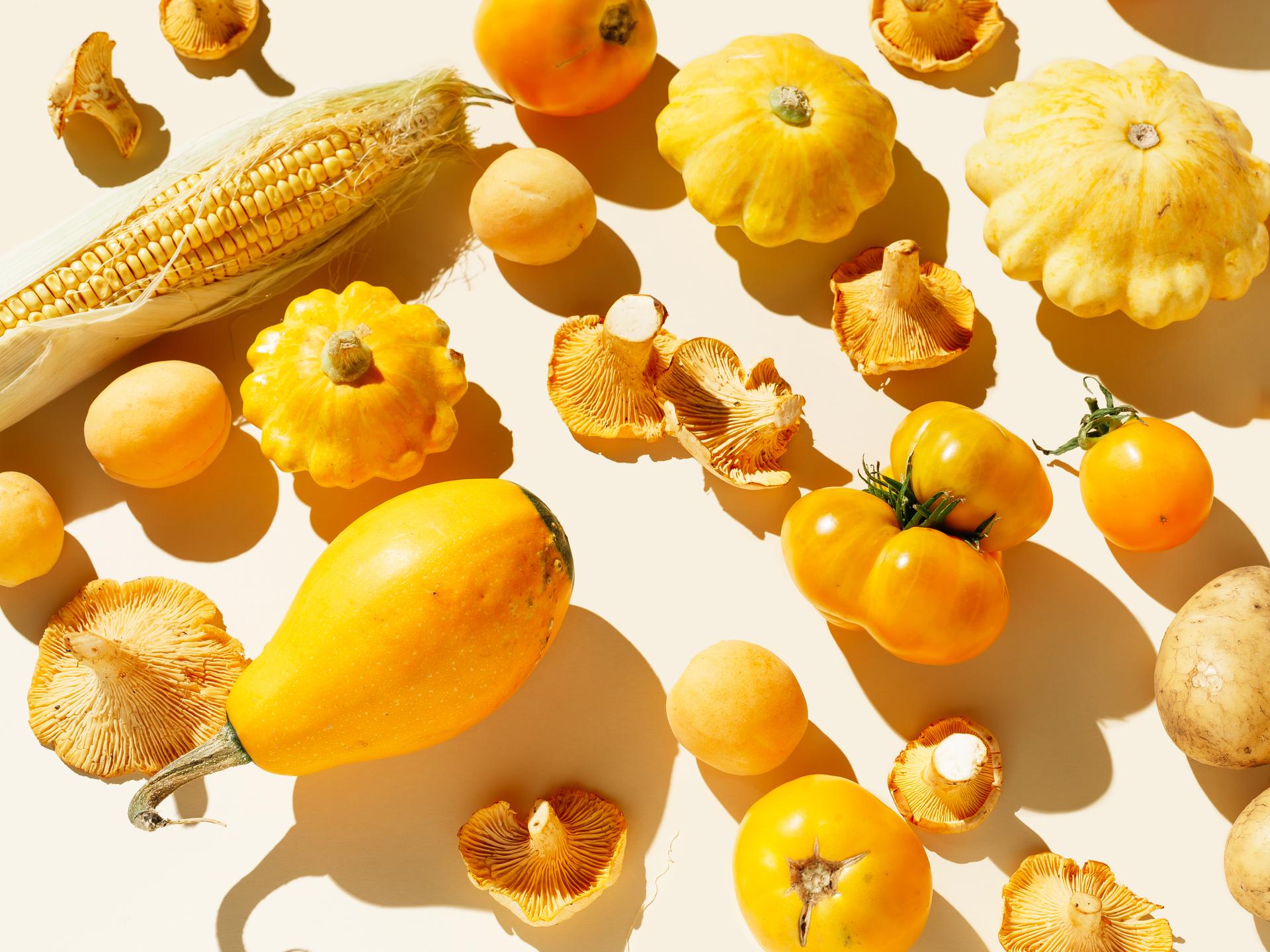 Frisches gelbes Bio-Gemüse und Obst auf hellem Hintergrund.