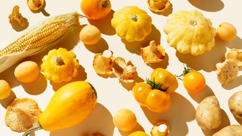 Frisches gelbes Bio-Gemüse und Obst auf hellem Hintergrund.