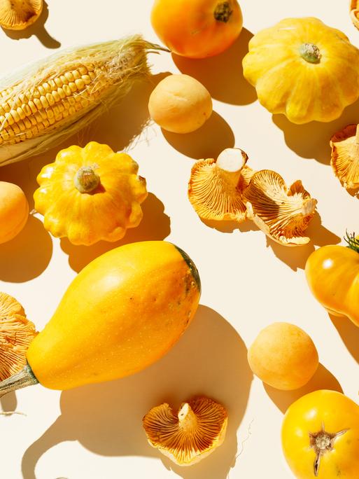Frisches gelbes Bio-Gemüse und Obst auf hellem Hintergrund.