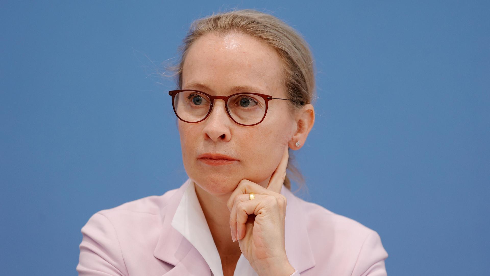 Prof. Frauke Brosius-Gersdorf sitzt vor einem blauen Hintergrund und stützt ihre Kopf auf die Hand