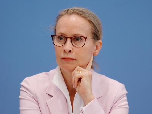 Prof. Frauke Brosius-Gersdorf sitzt vor einem blauen Hintergrund und stützt ihre Kopf auf die Hand