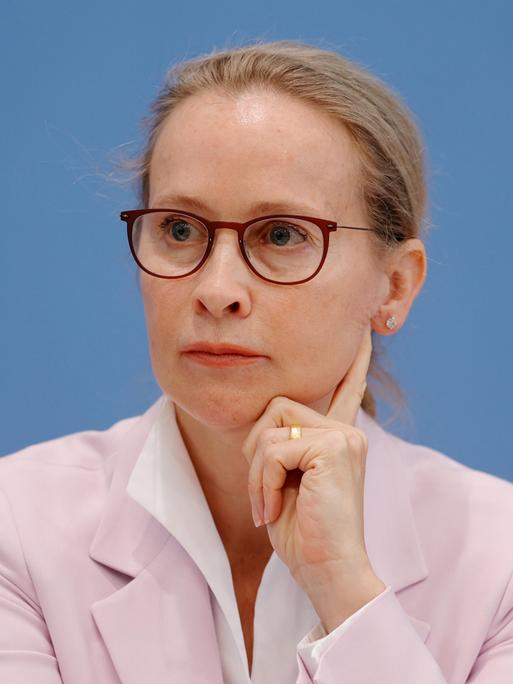 Prof. Frauke Brosius-Gersdorf sitzt vor einem blauen Hintergrund und stützt ihre Kopf auf die Hand