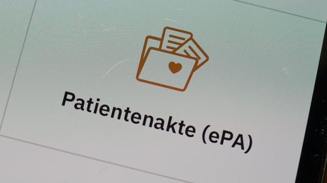 Auf einem Bildschirm steht "Patienten-Akte", darüber ist das Symbol einer Akte.