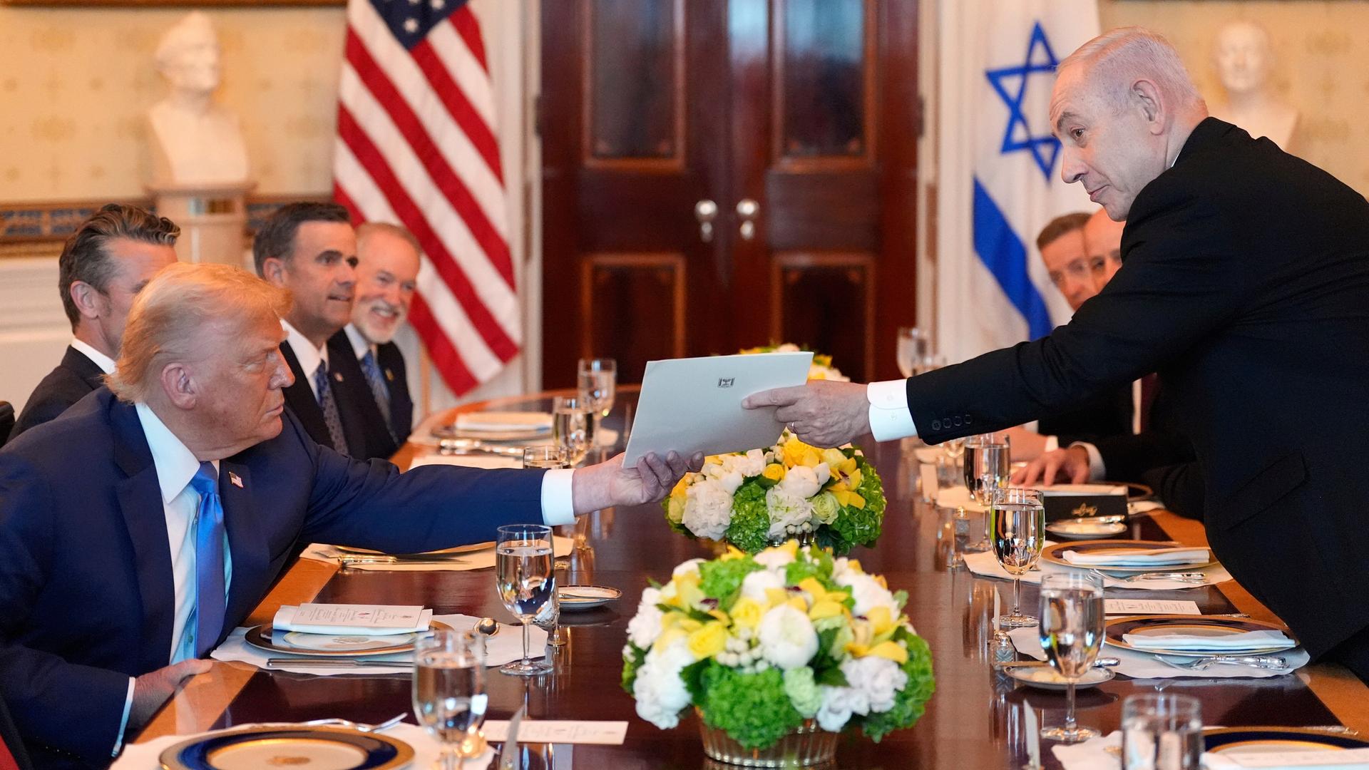 Israels Premierminister Benjamin Netanjahu (rechts) überreicht US-Präsident Donald Trump während eines Treffens im Blauen Saal des Weißen Hauses in Washington einen Umschlag. 