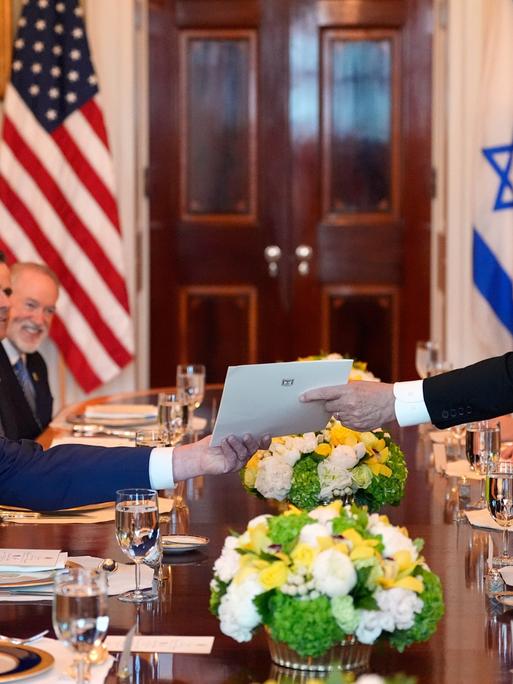 Israels Premierminister Benjamin Netanjahu (rechts) überreicht US-Präsident Donald Trump während eines Treffens im Blauen Saal des Weißen Hauses in Washington einen Umschlag. 