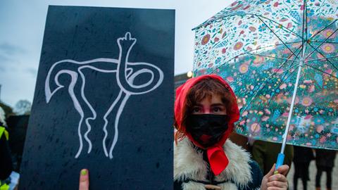 Eine Frau hält aus Solidarität mit polnischen Frauen ein Plakat mit einer darauf gezeichneten Gebärmutter während des Protests gegen das Abtreibungsverbot in Den Haag
