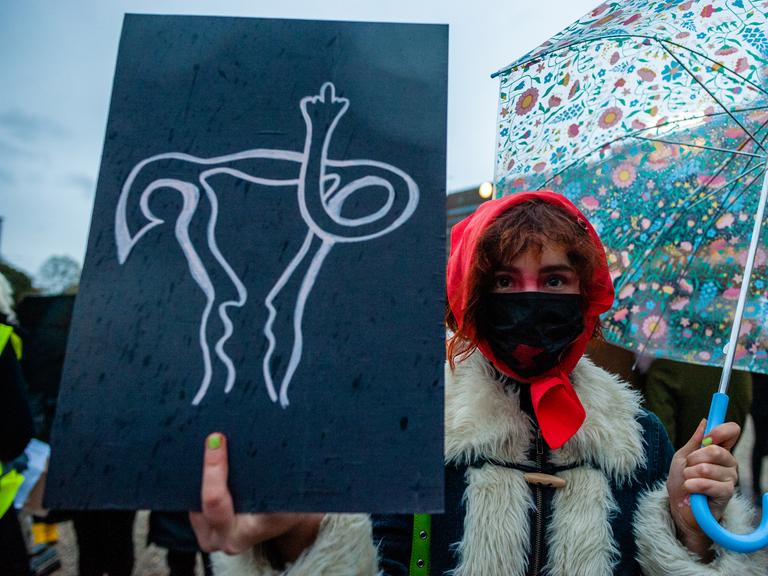 Eine Frau hält aus Solidarität mit polnischen Frauen ein Plakat mit einer darauf gezeichneten Gebärmutter während des Protests gegen das Abtreibungsverbot in Den Haag