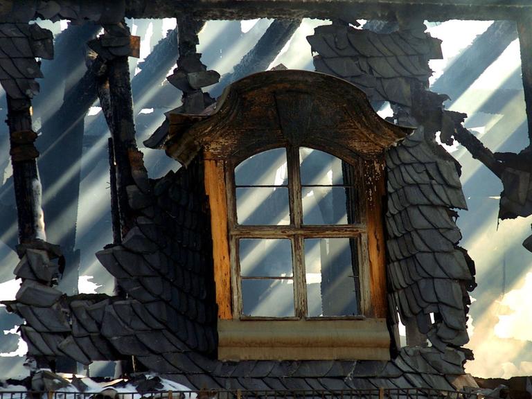 Hinter einem Dachfenster der Anna Amalia Bibliothek in Weimar scheint am 03.09.2004 die Sonne durchs verkohlte Gebälk.