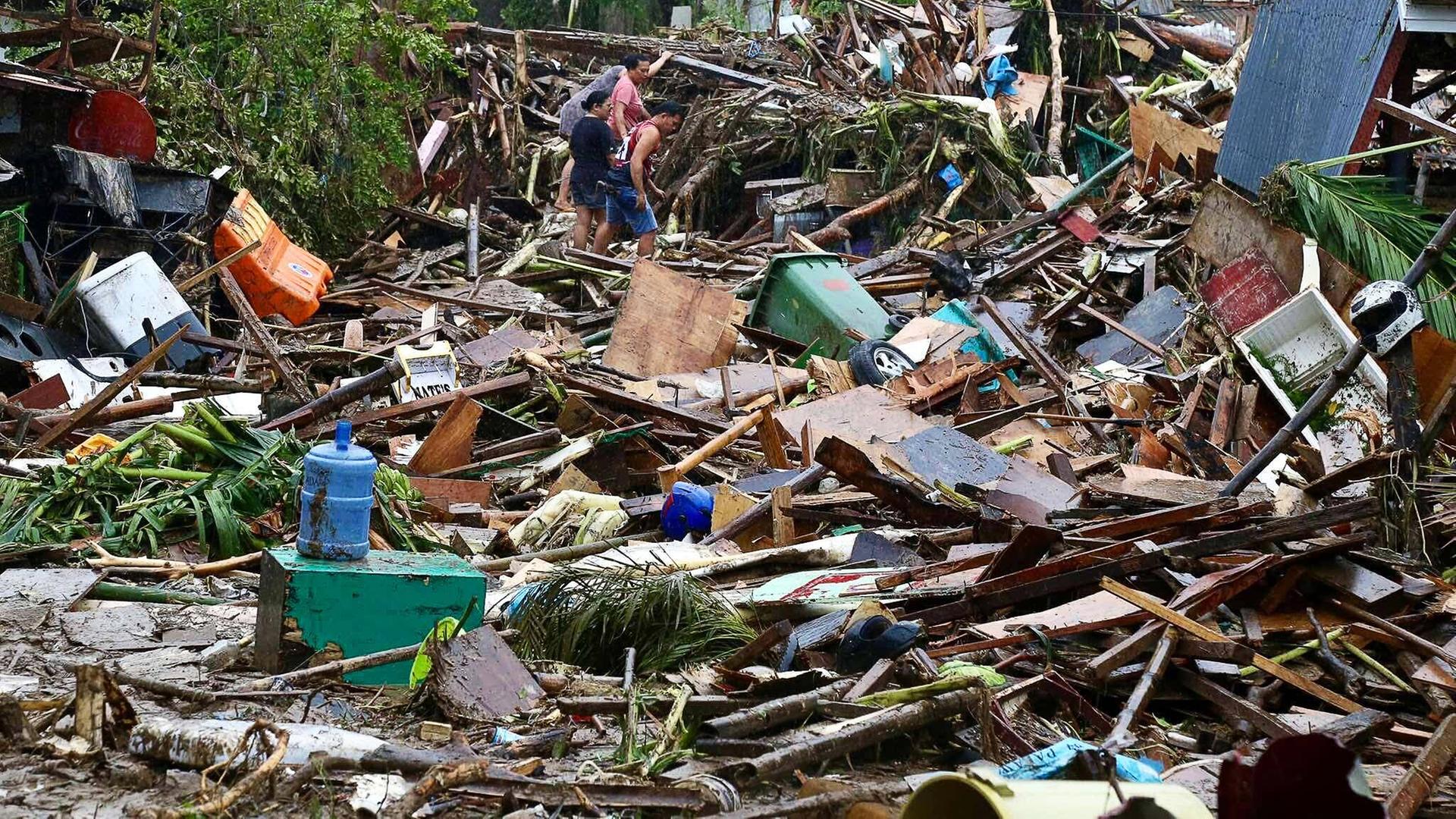Menschen laufen durch Trümmer nach Überschwemmungen durch den Taifun "Kalmaegi" in der Provinz Cebu. Menschen laufen durch Trümmer nach Überschwemmungen durch den Taifun "Kalmaegi" in der Provinz Cebu.