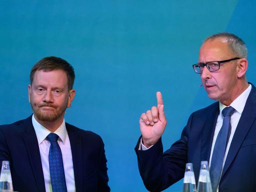 Michael Kretschmer (CDU, l), Ministerpräsident von Sachsen, und Jörg Urban, Vorsitzender der AfD in Sachsen, stehen beim Wahlforum der drei großen sächsischen Tageszeitungen zur Landtagswahl im Stromwerk im Kraftwerk Mitte auf dem Podium. 