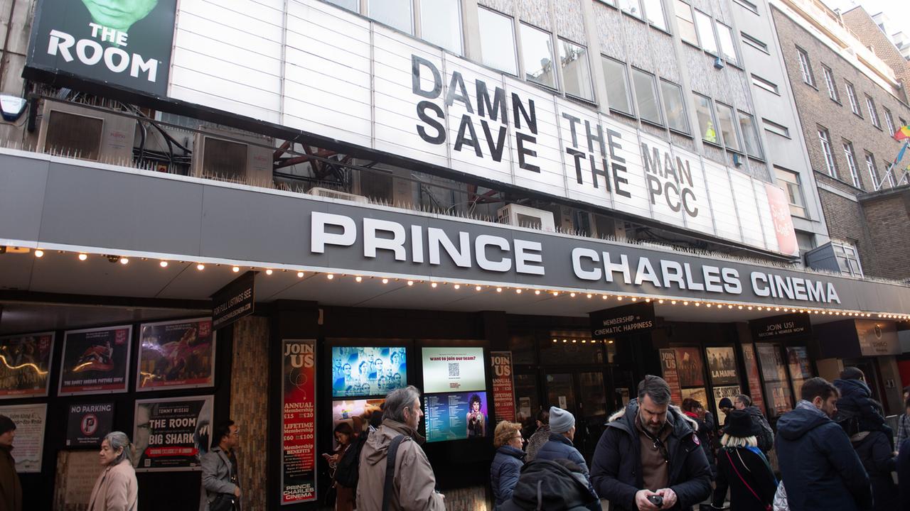 Das Prince Charles Cinema in London. Vor dem Eingang stehen Menschen. Auf der Anzeigetafel wird zur Rettung des Kinos aufgerufen.