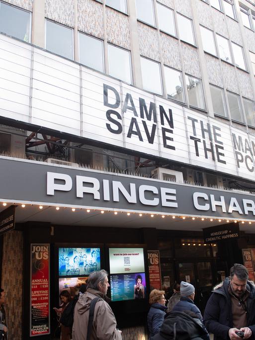 Das Prince Charles Cinema in London. Vor dem Eingang stehen Menschen. Auf der Anzeigetafel wird zur Rettung des Kinos aufgerufen.