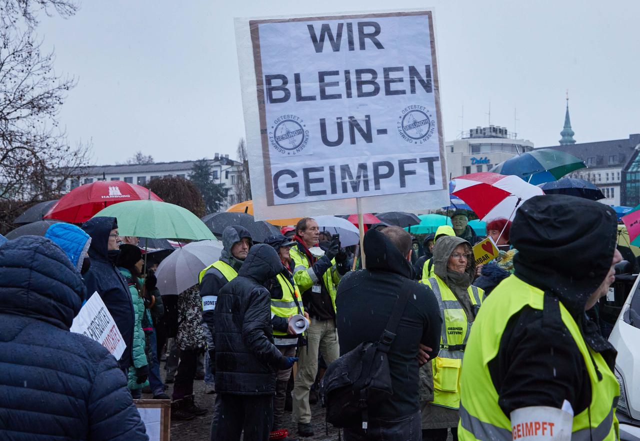 Ein Teilnehmer einer Demonstration von Corona-Impfgegnern hält ein Transparent mit den Aufschrift "Wir bleiben ungeimpft".