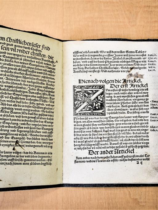 Ein aufgeschlagenes Buch zeigt die einen Originaldruck der "Zwölf Artikel" aus Memmingen aus der Zeit des Deutschen Bauernkriegsim Jahr 1525.