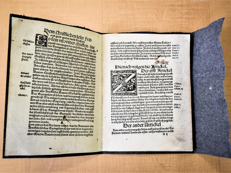 Ein aufgeschlagenes Buch zeigt die einen Originaldruck der "Zwölf Artikel" aus Memmingen aus der Zeit des Deutschen Bauernkriegsim Jahr 1525.