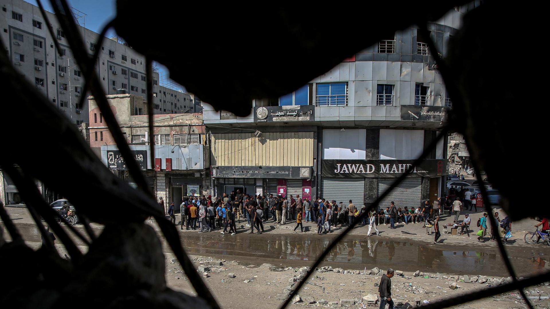 23. Oktober 2025, Gaza-Stadt, Gazastreifen, Palästinensisches Gebiet: Palästinenser stehen vor einer Bank Schlange, nachdem diese aufgrund des anhaltenden israelischen Krieges gegen den Gazastreifen in der vergangenen Zeit geschlossen war. 23. Oktober 2025, Gaza-Stadt, Gazastreifen, Palästinensisches Gebiet: Palästinenser stehen vor einer Bank Schlange, nachdem diese aufgrund des anhaltenden israelischen Krieges gegen den Gazastreifen in der vergangenen Zeit geschlossen war.