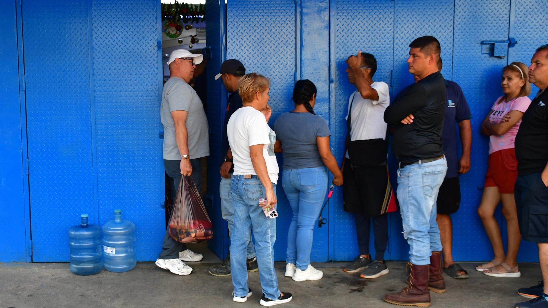 Anstehen für Lebensmittel: Menschen in Caracas stehen vor einem Supermarkt und warten auf Einlass Anstehen für Lebensmittel: Menschen in Caracas stehen vor einem Supermarkt und warten auf Einlass