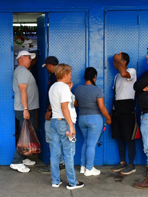 Anstehen für Lebensmittel: Menschen in Caracas stehen vor einem Supermarkt und warten auf Einlass