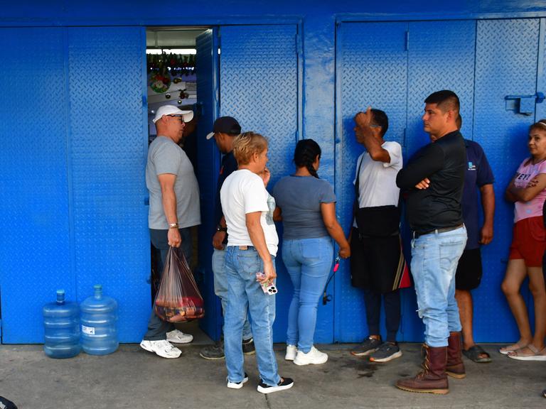 Anstehen für Lebensmittel: Menschen in Caracas stehen vor einem Supermarkt und warten auf Einlass