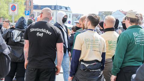 Von hinten abgebildete Teilnehmer der Demo der rechtsextremen Splitterpartei "III. Weg". Auf einem T-Shirt steht auf dem Rücken eines Glatzkopfes in Frakturschrift "Unsterblicher Hass".